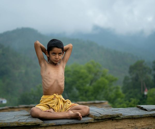 Person meditating outdoors with a calm natural background.