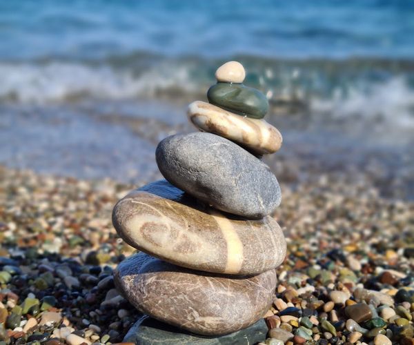 Stacked stones on a beach symbolizing balance and harmony.